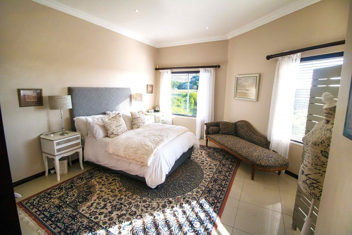A spacious bedroom featuring tiled flooring, recessed ceiling lighting, and large windows with curtain rods, offering a bright and comfortable living space.