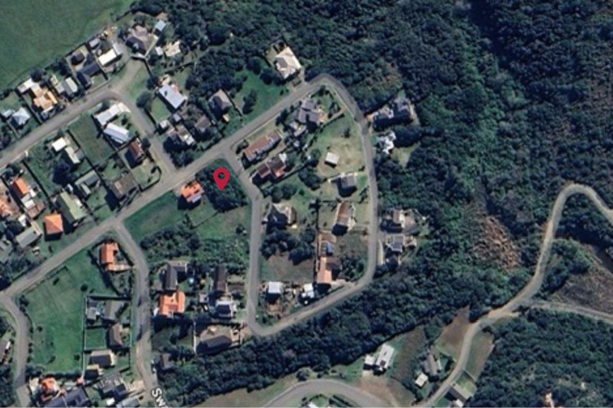 An aerial view of a residential neighborhood showing the location of the vacant land plot marked with a red pin.