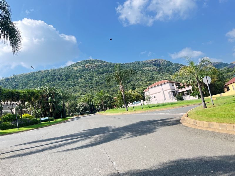 A view of the residential street and surrounding landscape, showcasing the neighborhood approach and mountain backdrop.