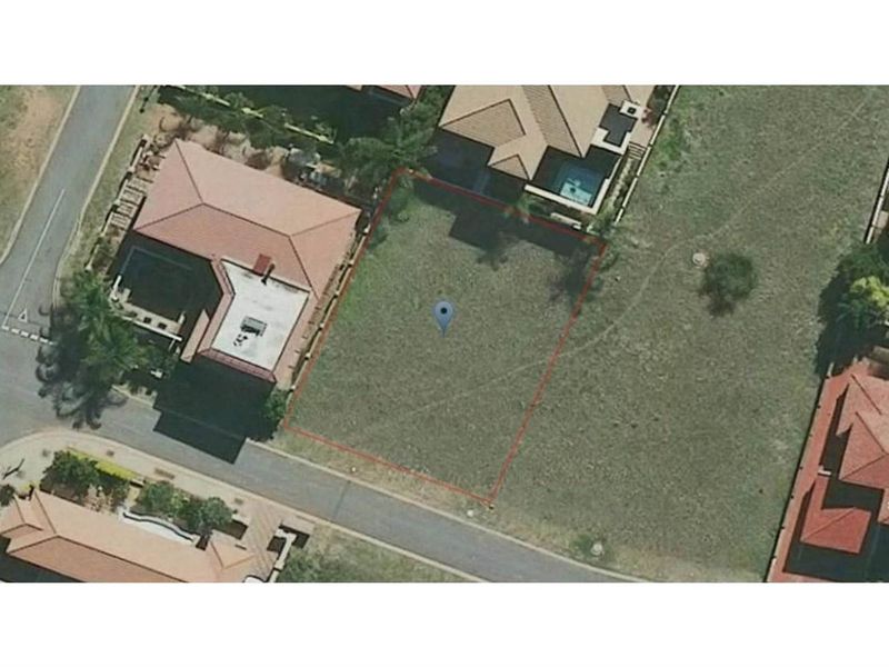 Aerial view of a vacant residential plot situated within an established neighborhood, featuring clear boundary lines and surrounding residential properties.