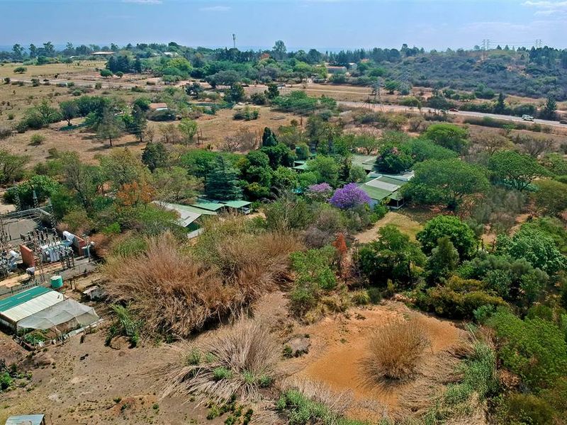Aerial view of a large, expansive property featuring mature landscaping, extensive grounds, and proximity to local infrastructure.