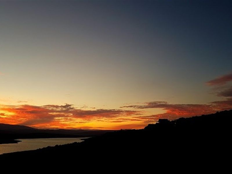 A scenic sunset view over the landscape and water, highlighting the natural beauty and tranquil setting of the property location.
