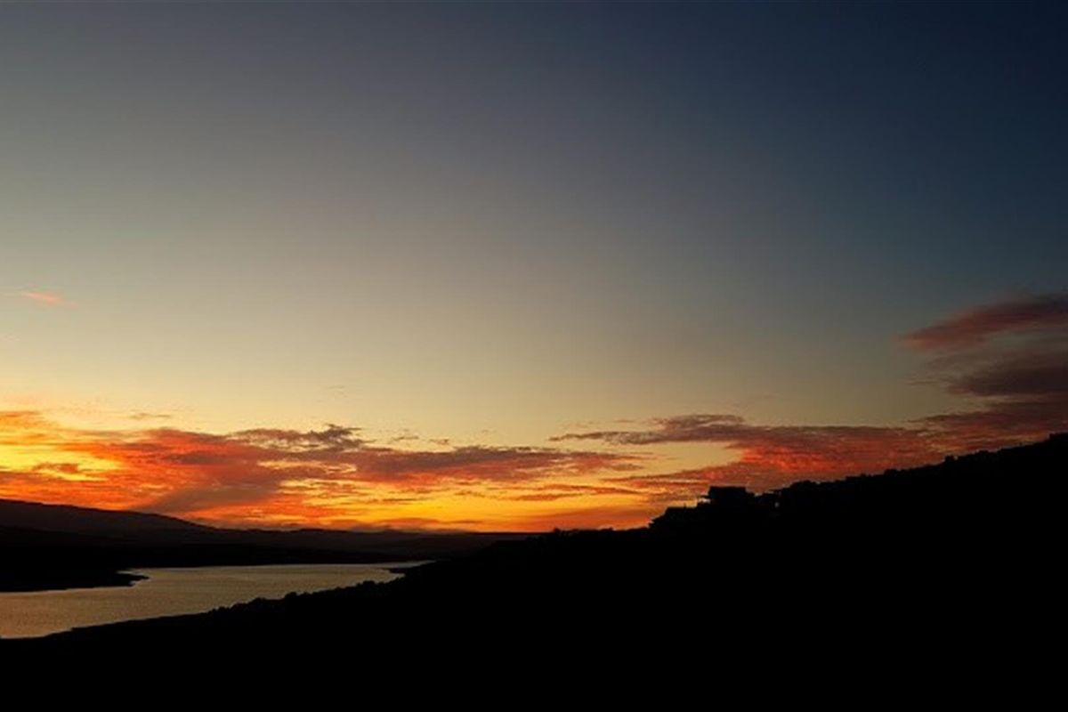 A scenic sunset view over the landscape and water, highlighting the natural beauty and tranquil setting of the property location.