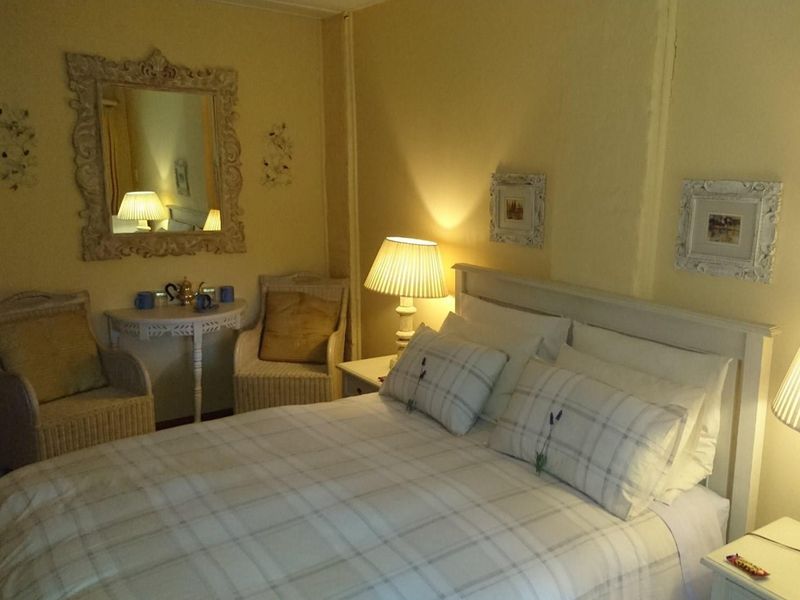 A cozy bedroom featuring warm lighting, neutral wall tones, and a classic layout suitable for a lodge or guest accommodation.