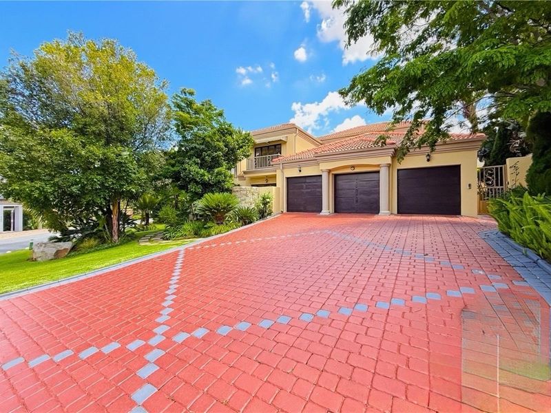 A well-maintained double-story residence featuring a triple garage, paved driveway, and established garden landscaping.