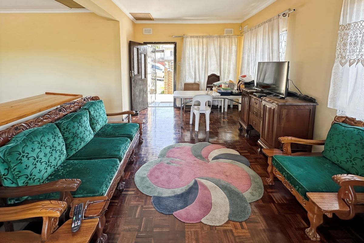 A spacious living area featuring traditional parquet flooring and direct access to the exterior entrance.