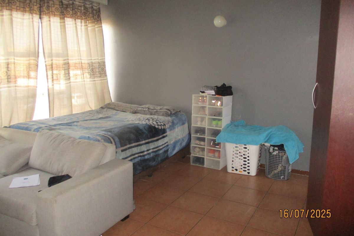 A bedroom featuring tiled flooring and a built-in wardrobe, providing a functional living space.