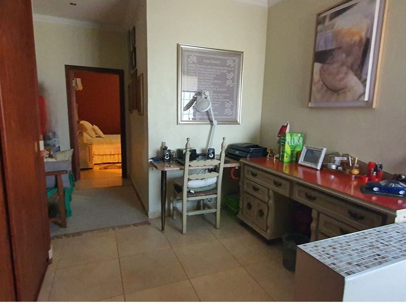 A functional hallway area featuring tiled flooring and built-in cabinetry, providing access to an adjacent bedroom.