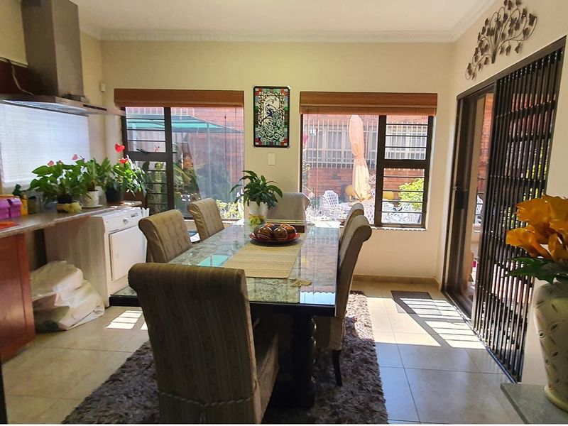 Open plan dining area featuring tiled flooring, large windows, and direct access to the outdoor patio through sliding doors.