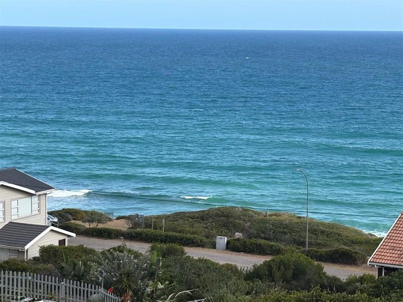 Elevated view overlooking the coastline and ocean, showcasing the property's proximity to the beach and surrounding coastal landscape.