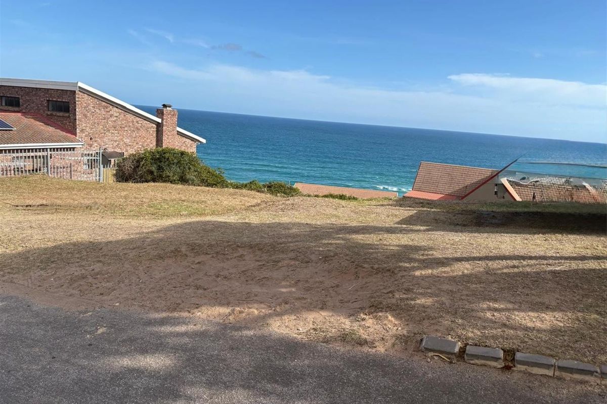 A vacant residential plot offering expansive ocean views, situated in a coastal neighborhood with established surrounding properties.