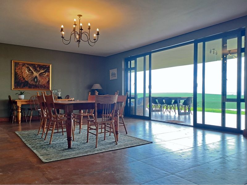 Spacious dining area featuring large sliding glass doors that open onto a covered patio, providing seamless indoor-outdoor flow and natural light.