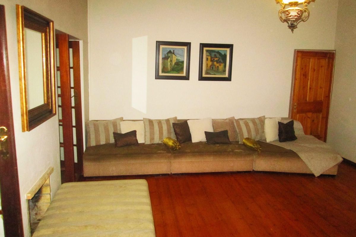 A living room featuring polished wooden flooring and a classic wooden door, providing a warm and traditional atmosphere.