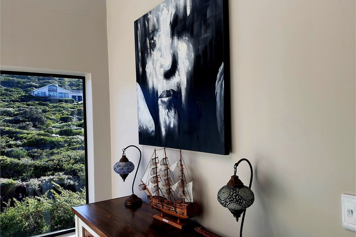 A bright living area featuring a large window with scenic hillside views and modern wall finishes.