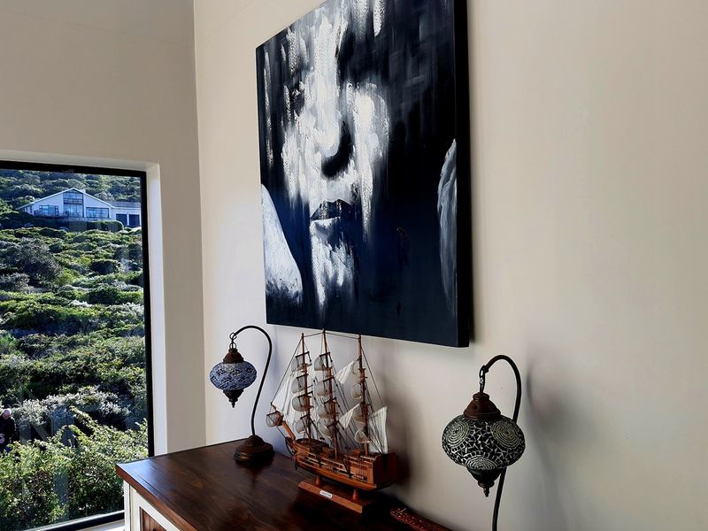 A bright living area featuring a large window with scenic hillside views and modern wall finishes.