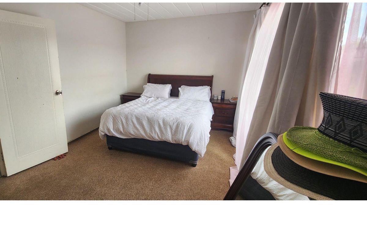 A bedroom featuring carpet flooring and a standard door, offering a functional space with natural light from the window.