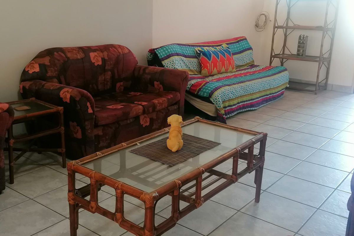 A living room area featuring neutral wall finishes and ceramic floor tiling throughout.