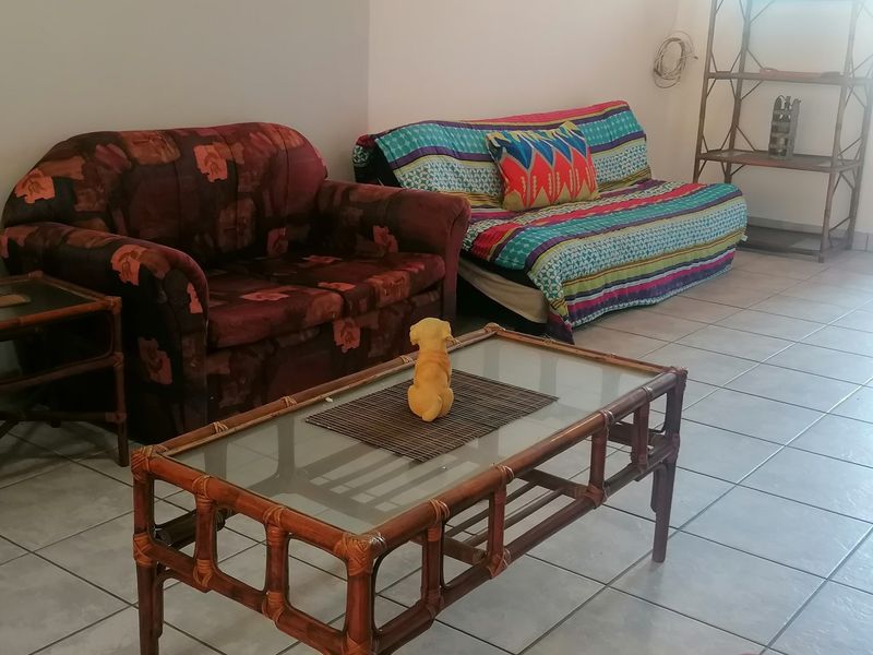 A living room area featuring neutral wall finishes and ceramic floor tiling throughout.