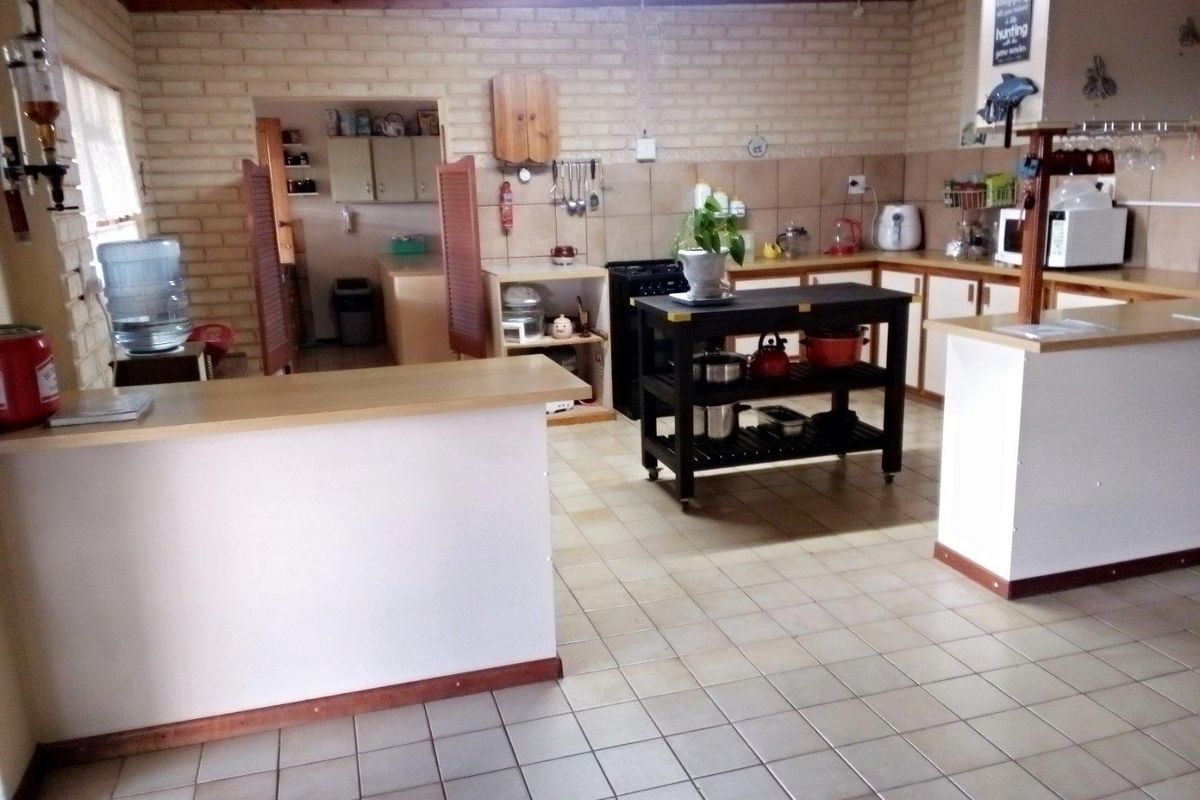 Spacious kitchen featuring tiled flooring, built-in cabinetry, and a functional layout with an adjoining scullery area.
