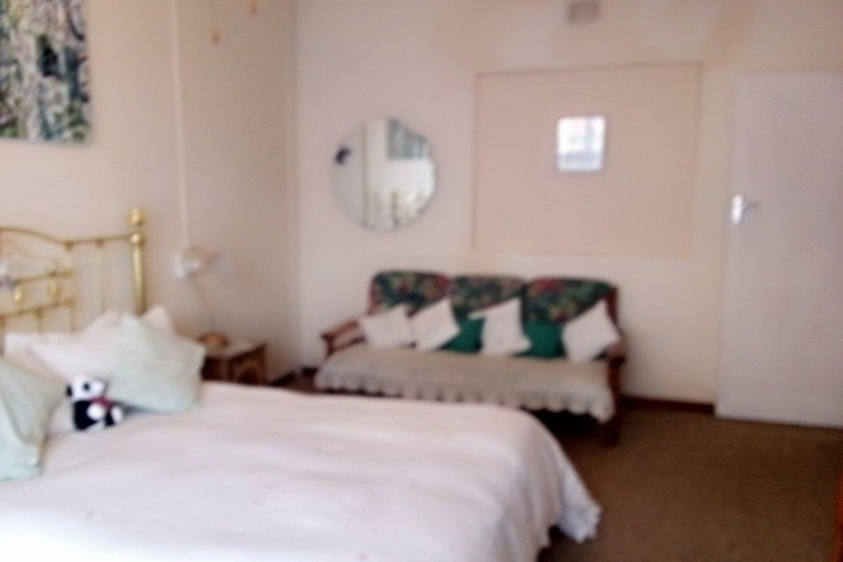 A bedroom featuring carpeted flooring and a recessed wall section, providing a functional space for rest.