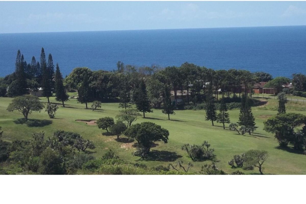 Elevated aerial view of a coastal residential property overlooking a lush green golf course and the ocean.