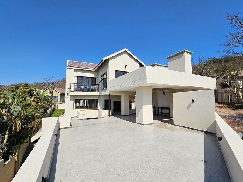 A spacious elevated patio area featuring a modern architectural design, clean lines, and a covered section, perfect for outdoor entertaining.