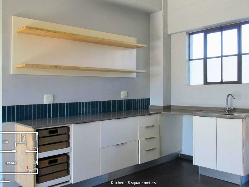 Modern kitchen featuring clean white cabinetry, stone countertops, tiled splashback, and floating shelves, complemented by an industrial-style window.
