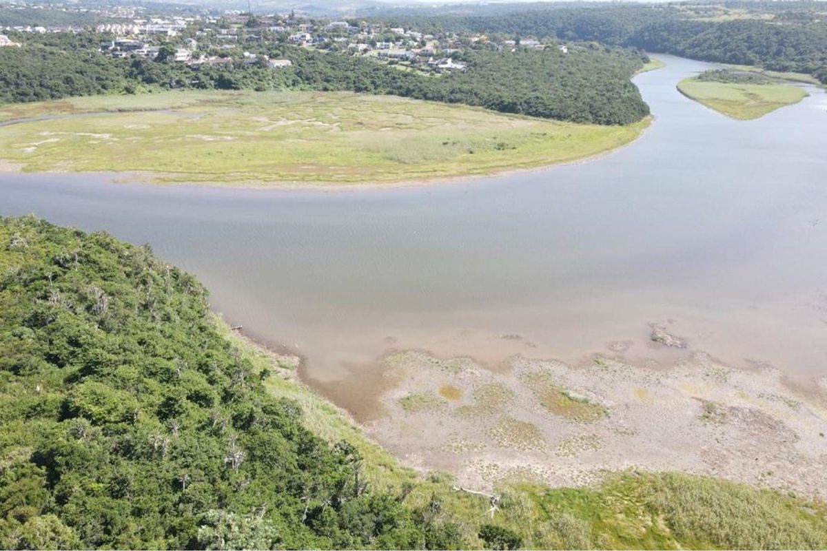 An elevated aerial view showcasing the natural landscape, river, and surrounding vegetation of the vacant residential land.