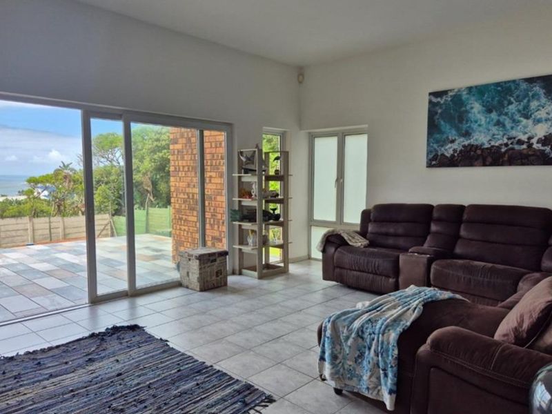 Spacious living room featuring large sliding glass doors that open to an outdoor patio area with scenic views.