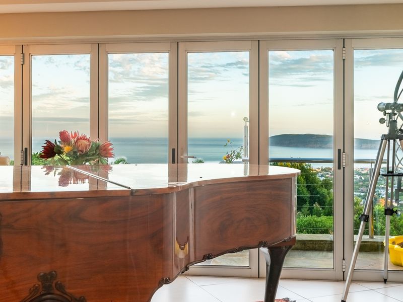 Spacious living area featuring large glass sliding doors that provide expansive ocean and coastal views.