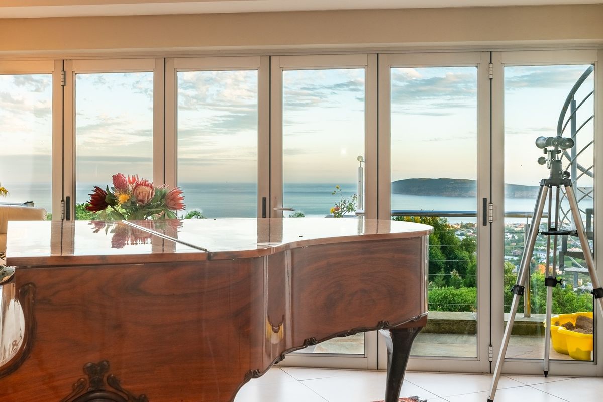 Spacious living area featuring large glass sliding doors that provide expansive ocean and coastal views.