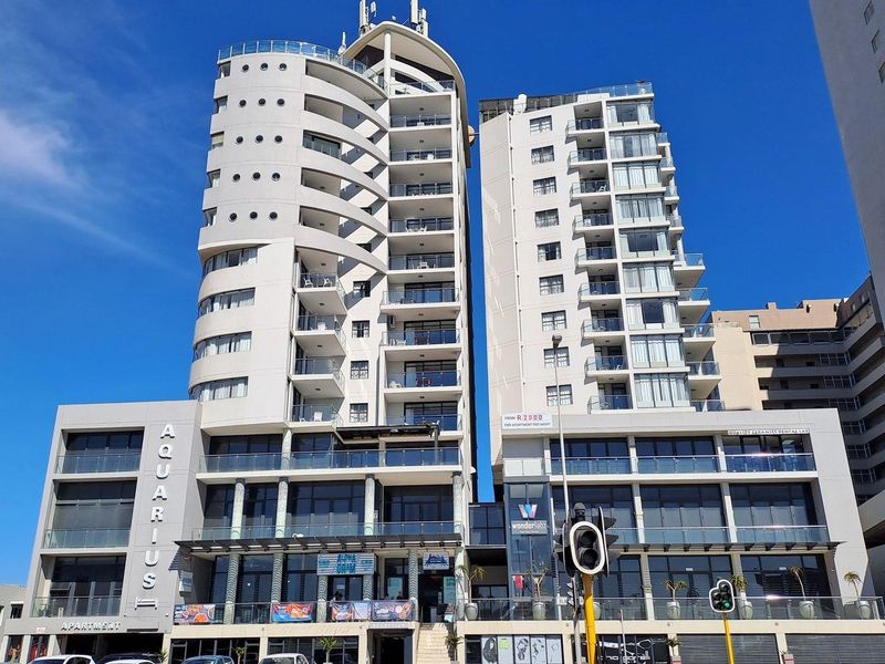 Front elevation of the Aquarius apartment building, featuring modern multi-story architecture with balconies and ground-level commercial space.