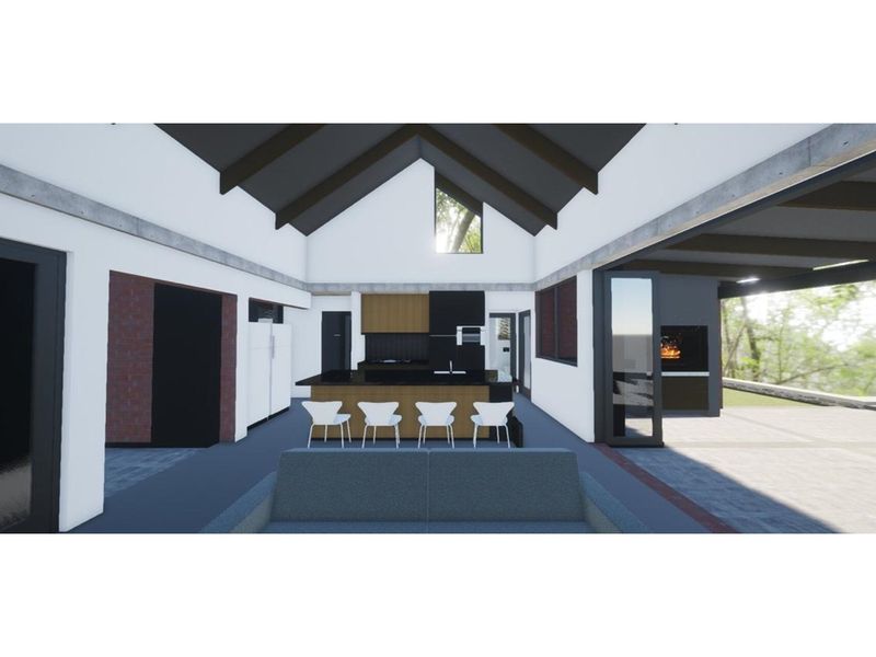 A modern open-plan living and kitchen area featuring vaulted ceilings, exposed beams, and seamless indoor-outdoor flow to a covered patio with a built-in fireplace.