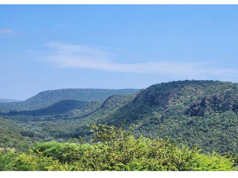 A scenic view of the surrounding natural landscape, featuring rolling hills and dense vegetation.