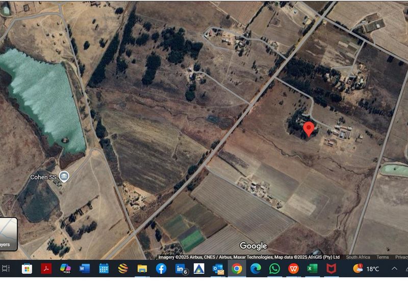An aerial satellite view of the farm property and surrounding rural landscape, showing access roads and nearby water features.
