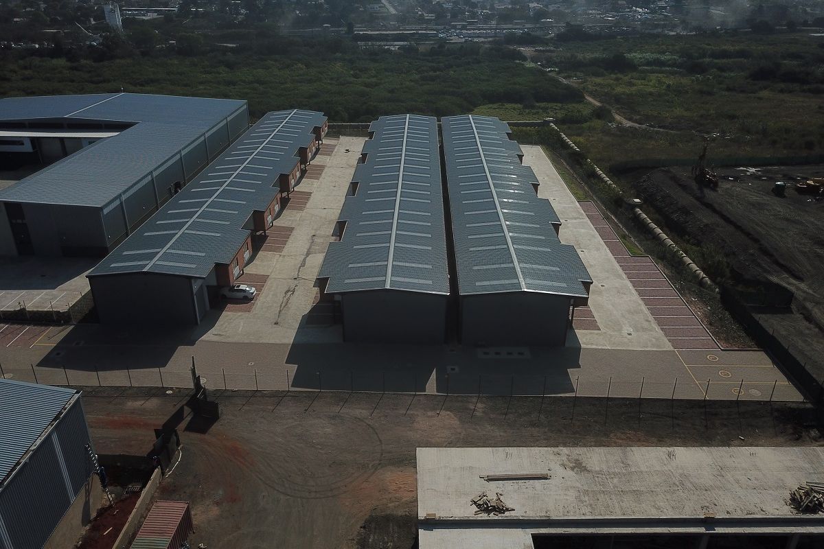 Aerial view of a modern industrial park featuring multiple warehouse units with metal roofing and paved access areas.