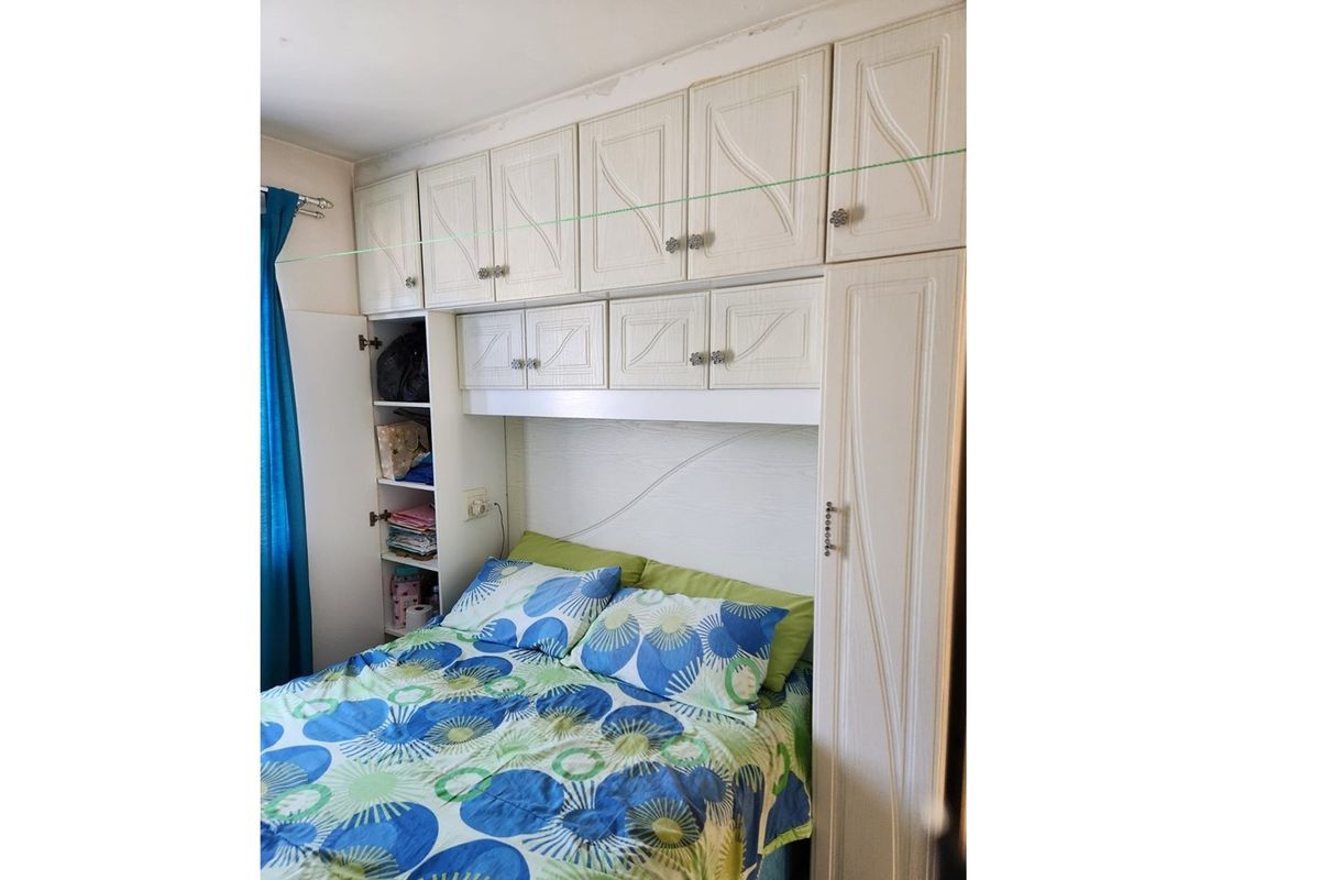 Bedroom featuring built-in overhead cabinetry and integrated side shelving for storage.