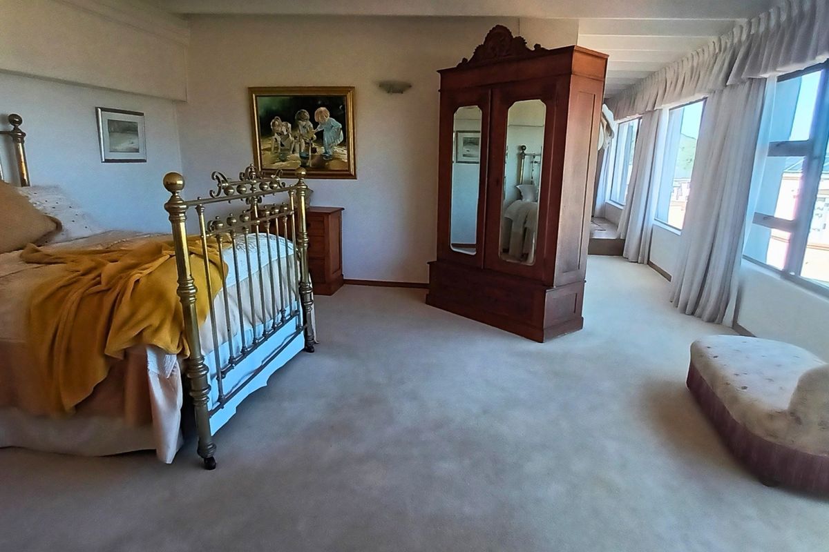 Spacious bedroom featuring neutral carpeting, large windows with natural light, and a clean, functional layout.