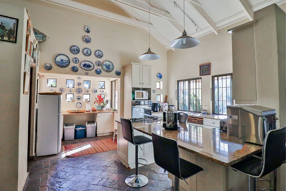 Spacious farmhouse kitchen featuring a central island with granite countertops, vaulted ceilings, and ample cabinetry, creating a warm and functional culinary space.