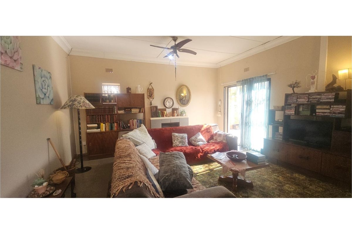 A comfortable living room featuring a ceiling fan and sliding glass doors that provide access to the outdoor area.