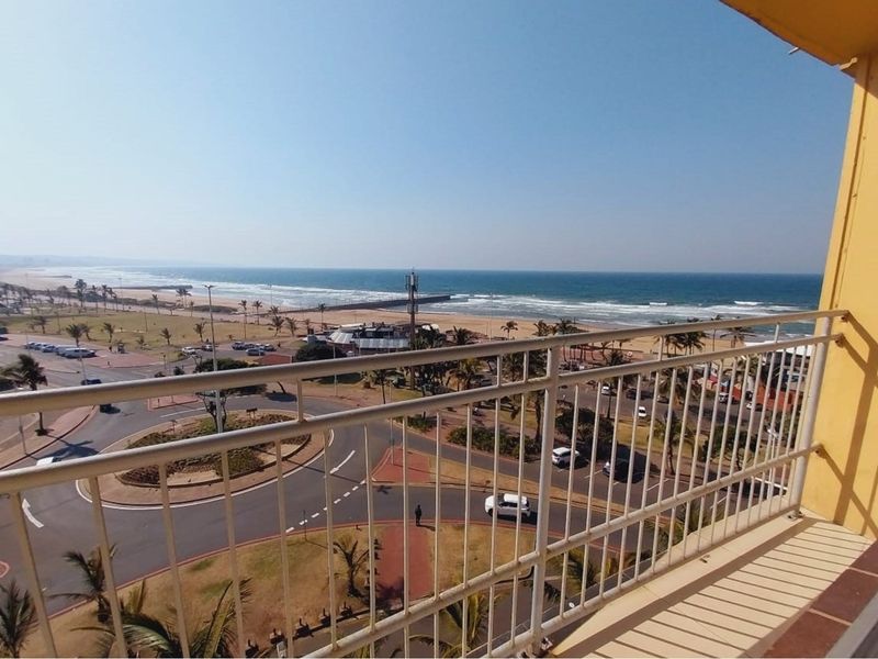 Elevated balcony offering expansive panoramic views of the coastline, beach, and surrounding urban landscape.