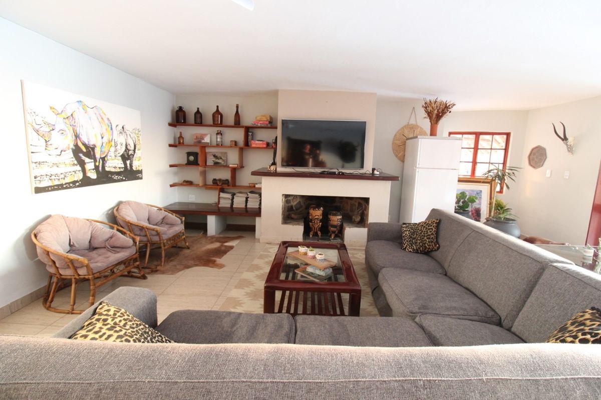 A comfortable living room featuring a central fireplace with built-in shelving and tiled flooring, creating a warm and inviting space.