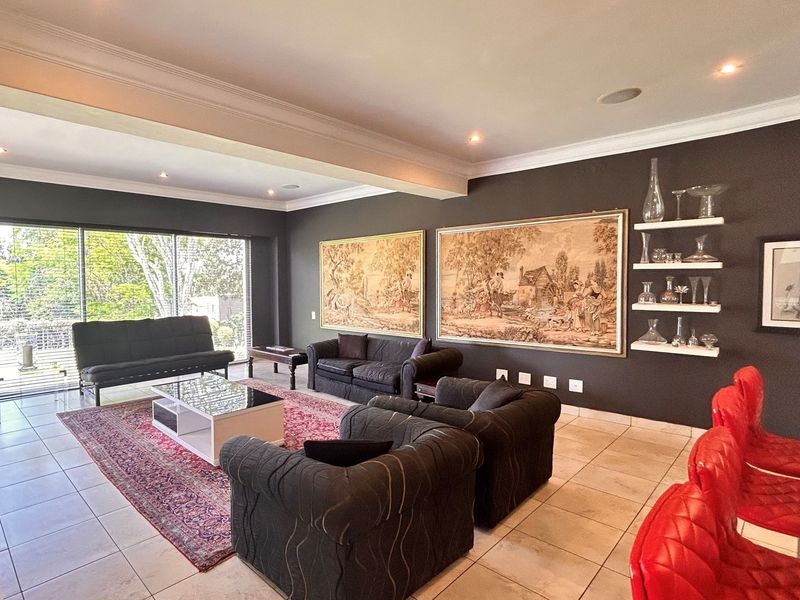 Spacious open-plan living area featuring large sliding glass doors, recessed ceiling lighting, and tiled flooring, offering a bright and versatile space.