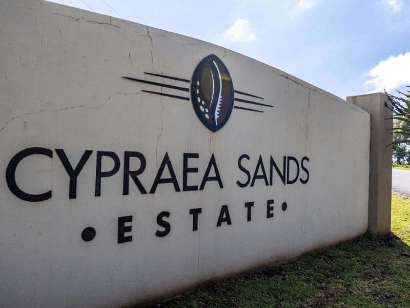 Entrance signage for Cypraea Sands Estate featuring a masonry boundary wall.