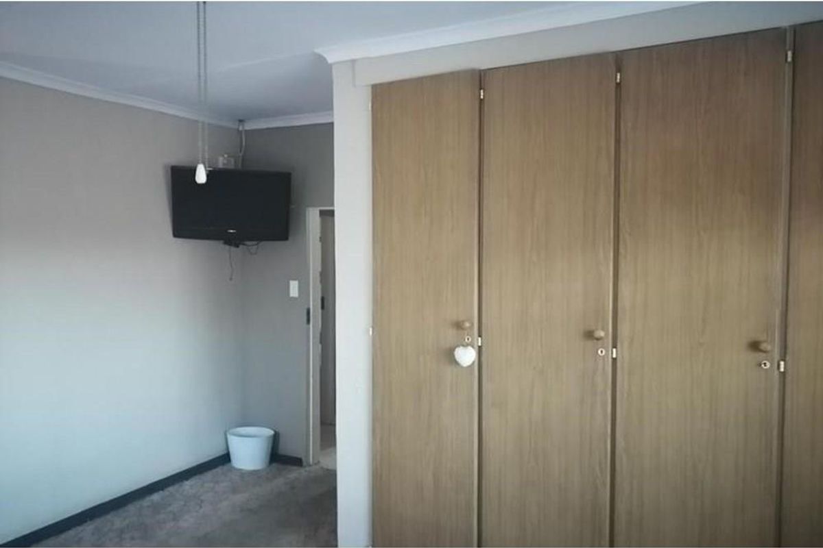 A bedroom featuring built-in wooden cabinetry and neutral wall finishes.