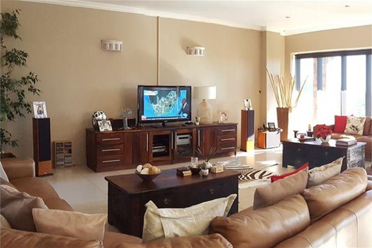 Spacious living room featuring tiled flooring, neutral wall tones, and large sliding glass doors providing ample natural light.