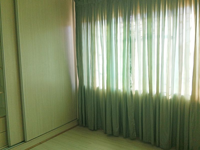 A bright, empty bedroom featuring light-toned laminate flooring and a spacious built-in wardrobe with sliding doors.