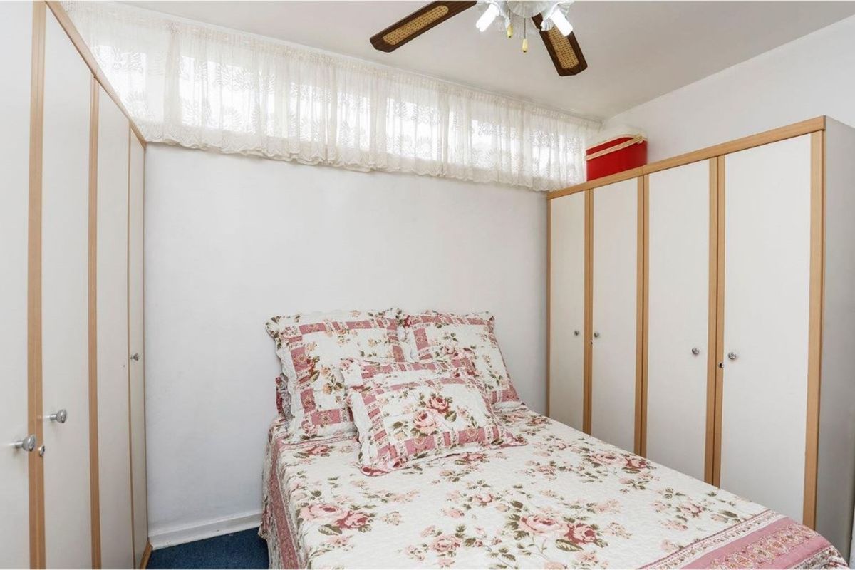 A bedroom featuring built-in wardrobes and a ceiling fan, providing functional storage and overhead lighting.