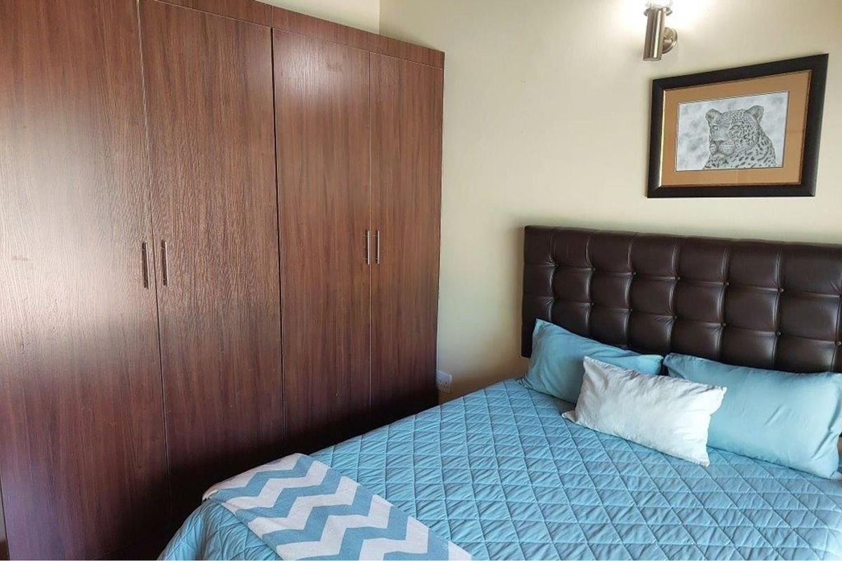 A bedroom featuring built-in wooden cabinetry and a wall-mounted light fixture.