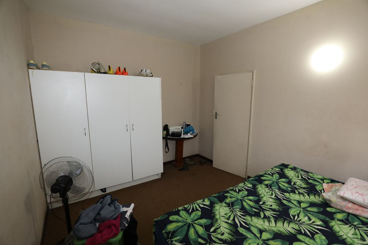 A bedroom featuring carpeted flooring and a built-in wardrobe, offering a functional space with potential for cosmetic updates.